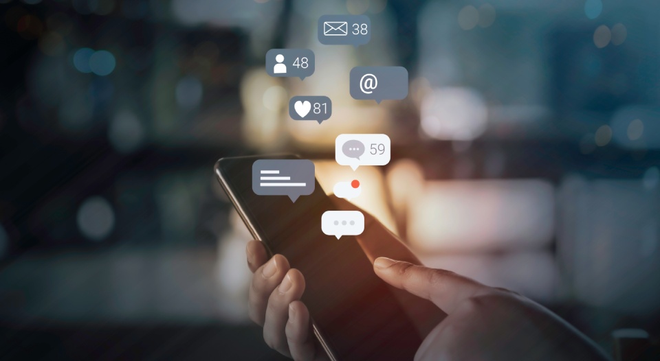 Person hand using a mobile phone with social media marketing concept.